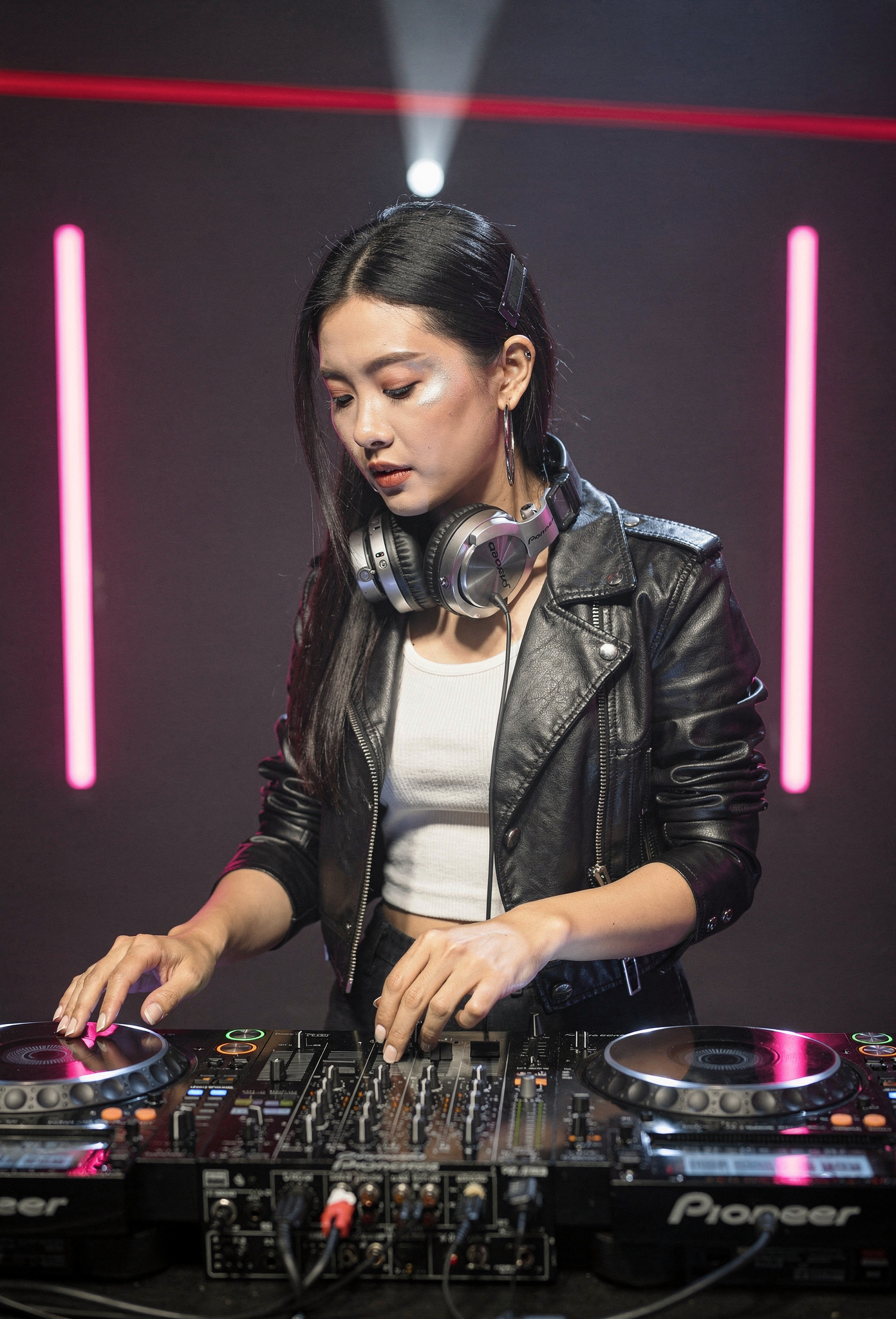 Kadın DJ sahne üzerinde Pioneer CDJ konsolunda performans sergiliyor