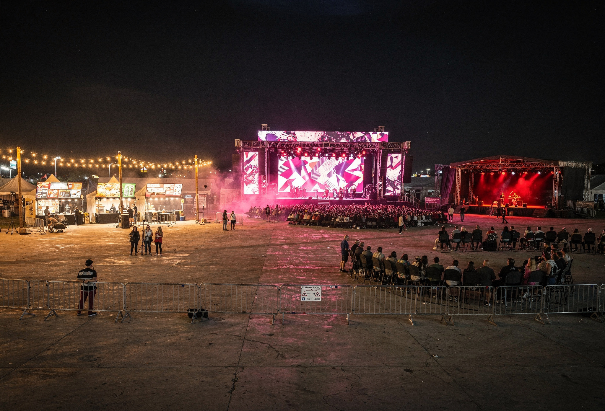 Gece festival alanı ana sahne ve yiyecek stantlarıyla genel manzara